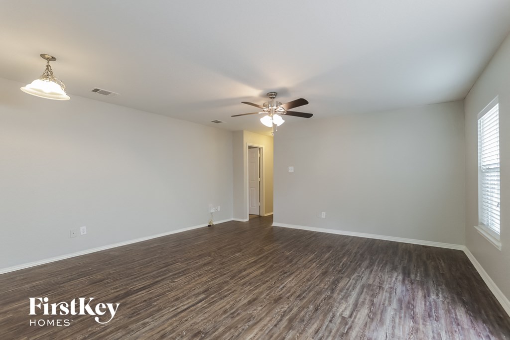 a living room with wood flooring and a ceiling fan