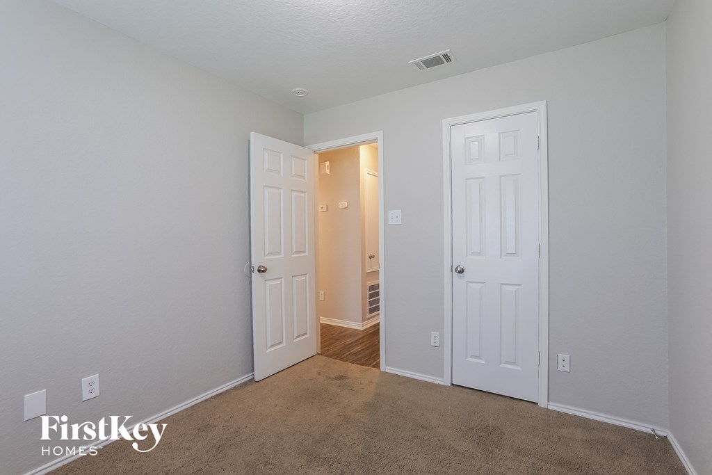 a bedroom with two closets and a door to a hallway