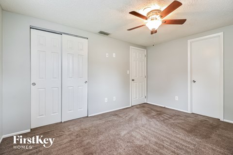 the living room of our studio apartment atrium with carpet and a ceiling fan