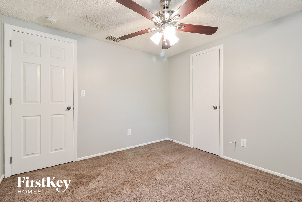 the living room of an empty house with a ceiling fan