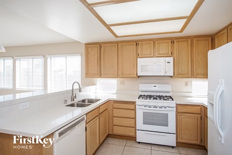 A kitchen with wooden cabinets and white appliances.