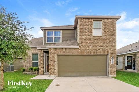 a tan brick house with a garage door