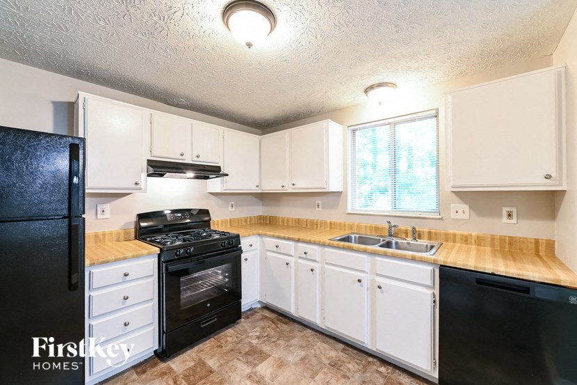 a kitchen with black appliances and white cabinets