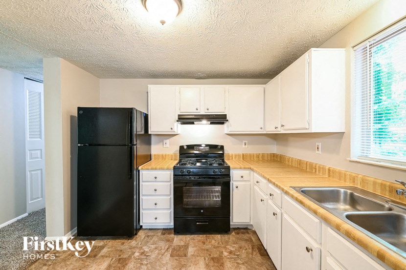 a kitchen with black appliances and white cabinets