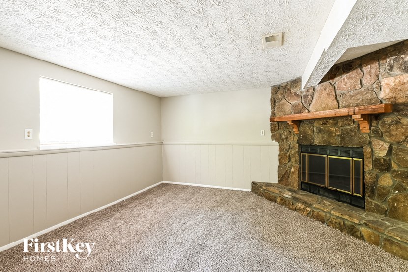a empty living room with a stone fireplace