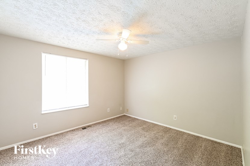 a empty room with a ceiling fan and a window
