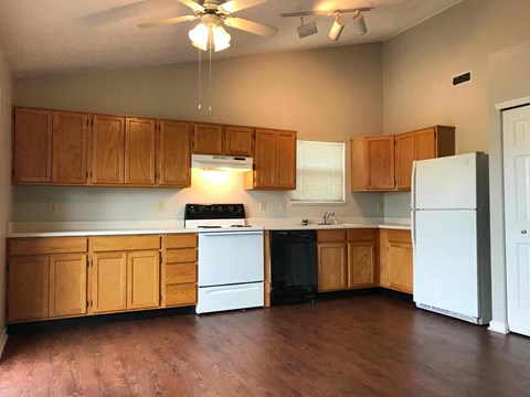 A kitchen with wooden cabinets and a white refrigerator.
