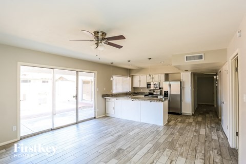 A spacious kitchen with a fan and a view of the outside.