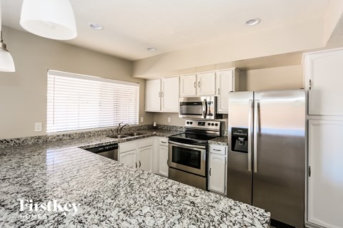 A kitchen with granite countertops and stainless steel appliances.