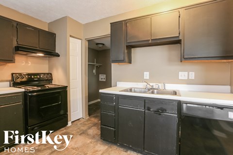 a kitchen with black appliances and white counter tops and a sink