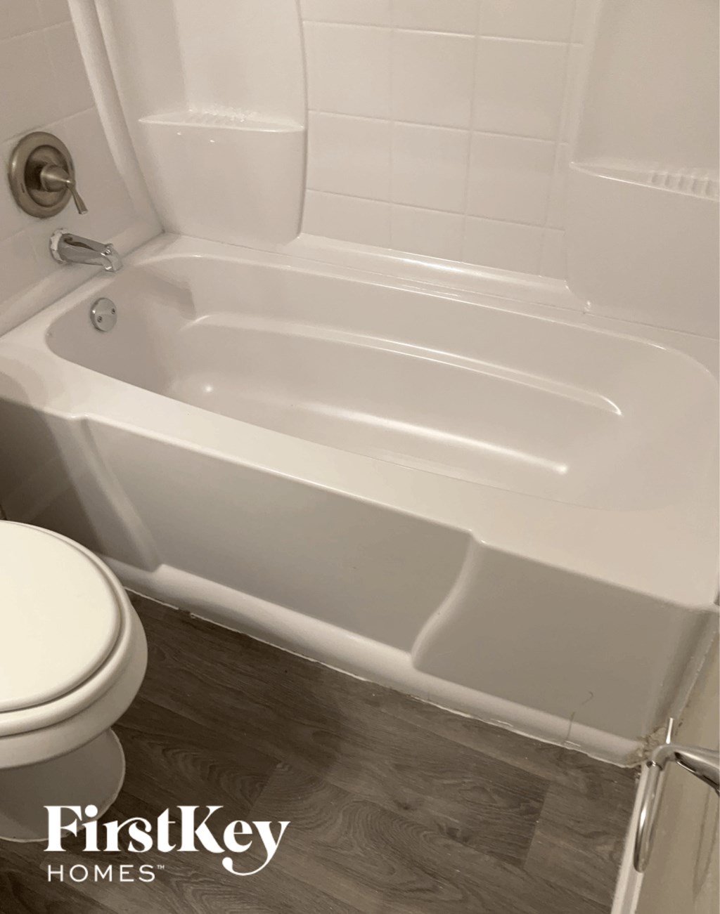 a white bath tub in a bathroom with a toilet