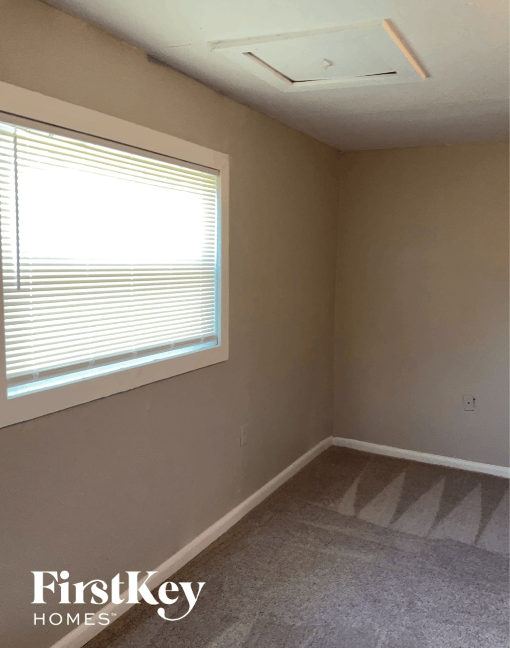 a small room with a window and a carpet