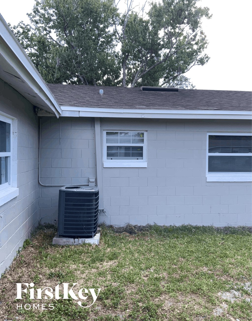 the side of a house with a heater in the yard