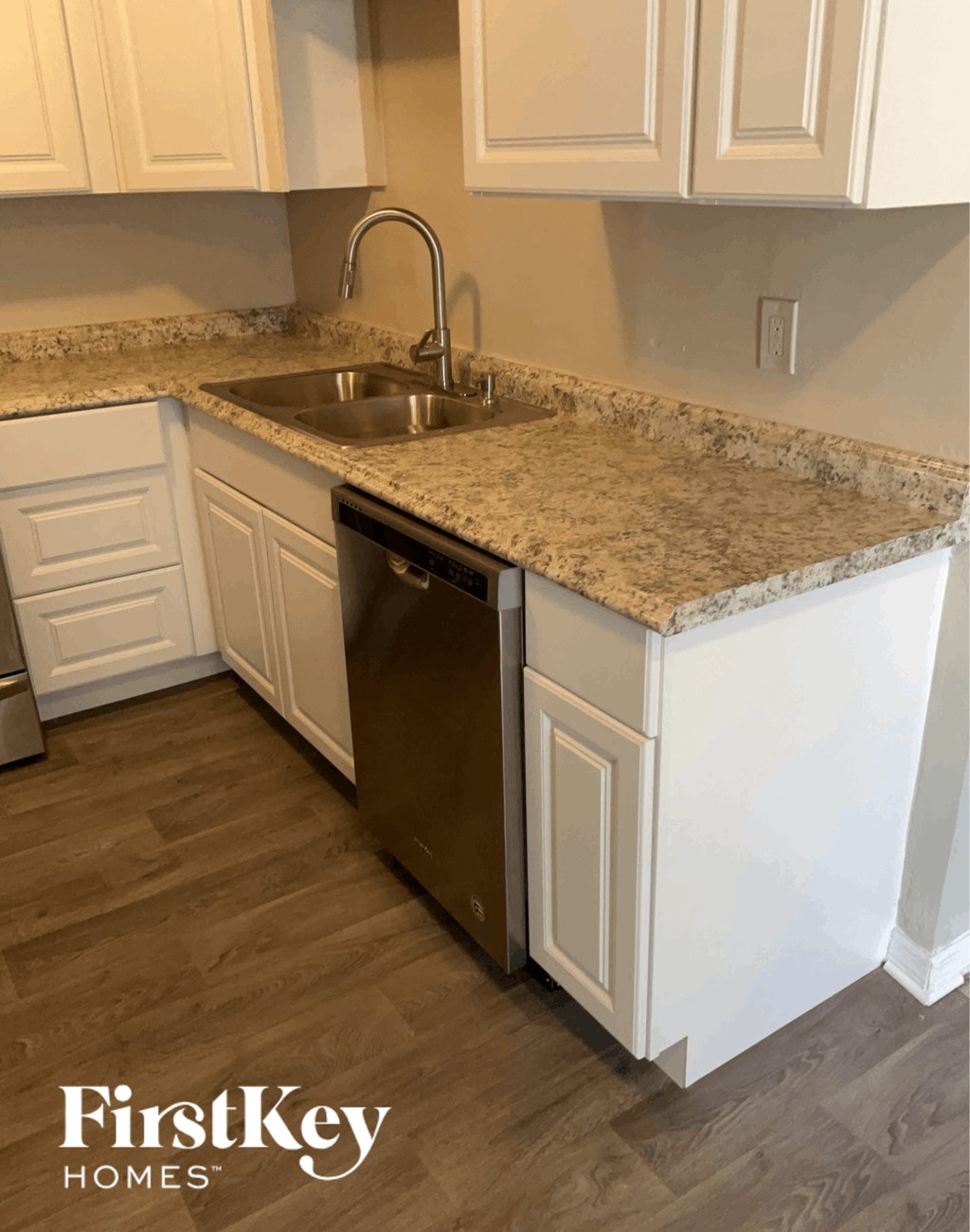 a kitchen with white cabinets and granite counter tops