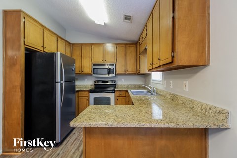 A kitchen with wooden cabinets and granite countertops.