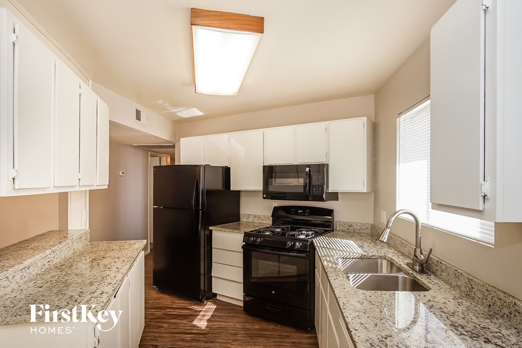 a kitchen with black appliances and granite counter tops