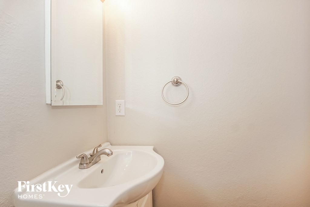 a white bathroom with a sink and a mirror