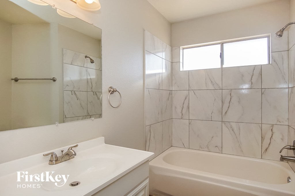 a bathroom with a sink and a bath tub and a mirror