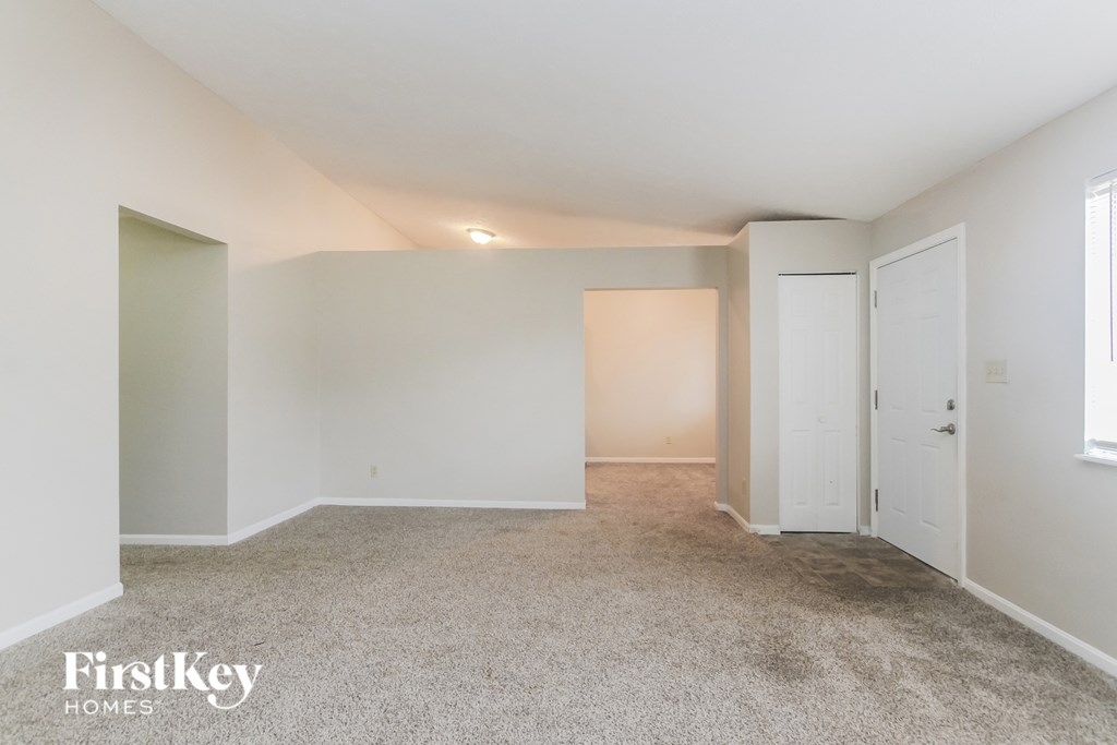 a bedroom with white walls and carpet and white doors