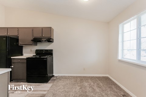 a kitchen with a stove and a dishwasher and a window