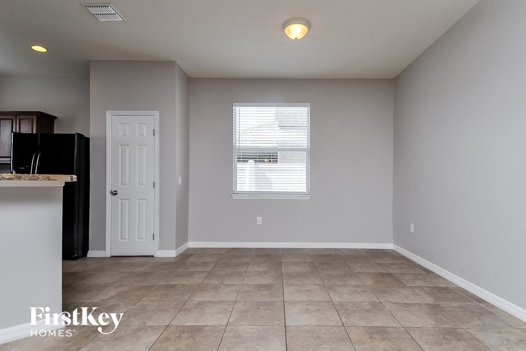 a kitchen and dining room with tile flooring and white walls