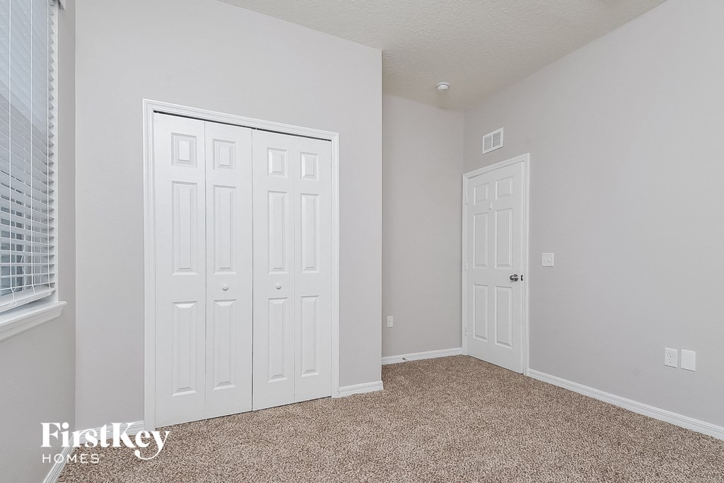 a bedroom with two closets and two doors