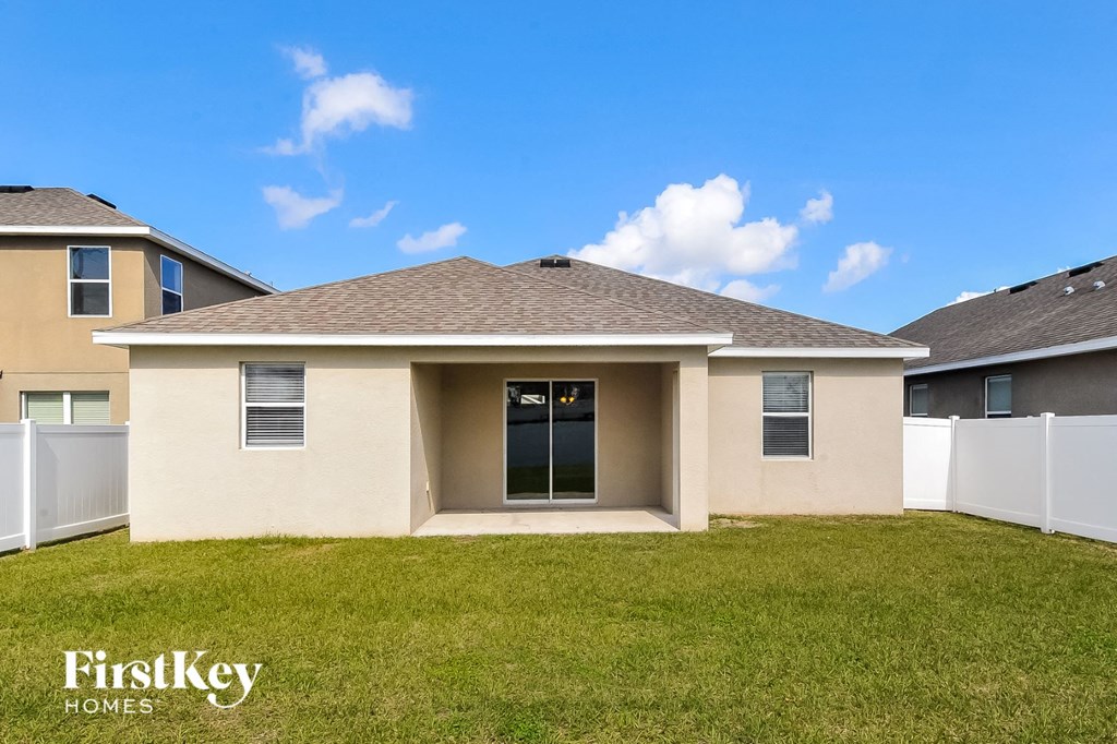 a beige house with a lawn and a blue sky