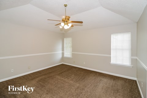a bedroom with a carpeted floor and a ceiling fan