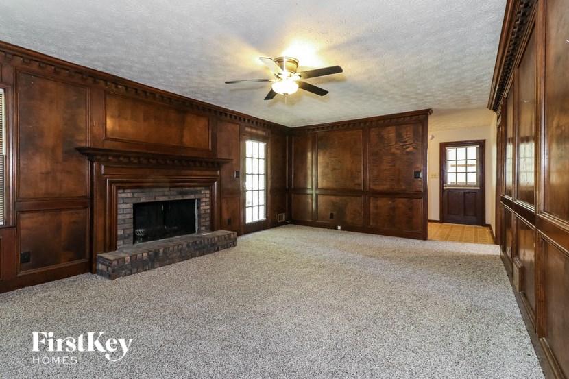 a living room with wood paneling and a fireplace