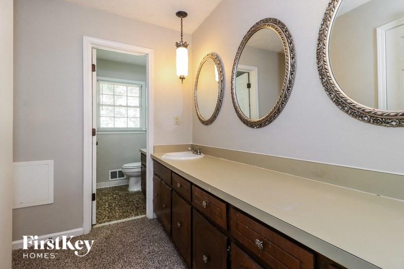 a bathroom with two mirrors and a sink and a toilet