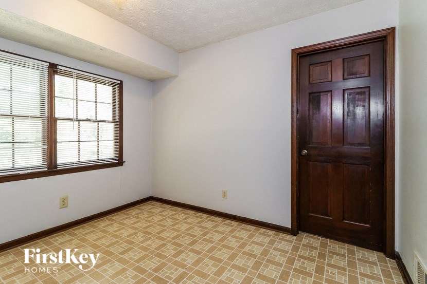 an empty living room with a wooden door and a window
