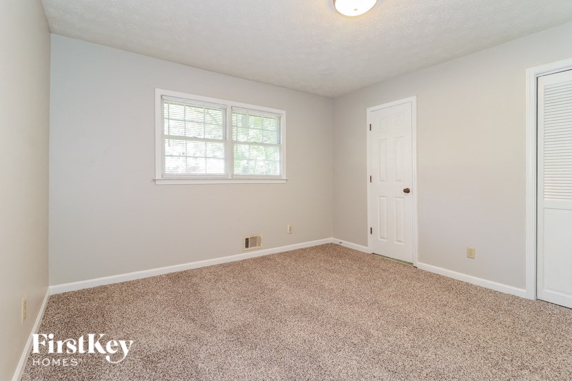 a bedroom with a carpeted floor and a white door