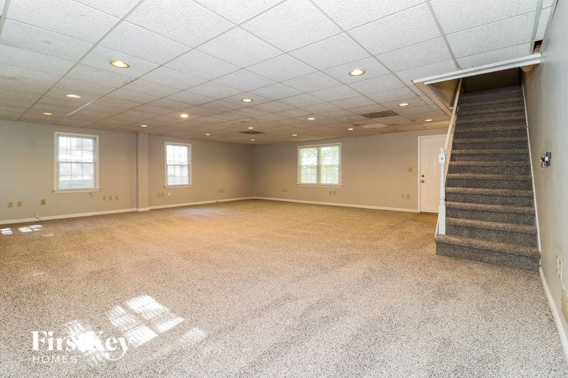 an empty room with a staircase and a carpeted floor
