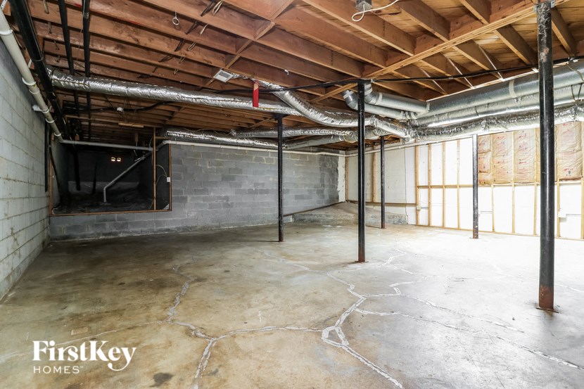 a large basement with concrete floors and exposed beams