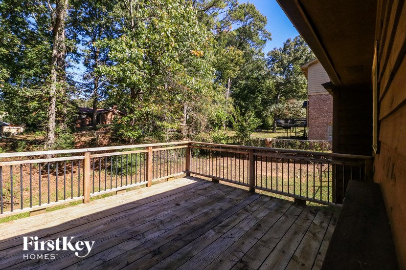a deck with a view of a yard and trees
