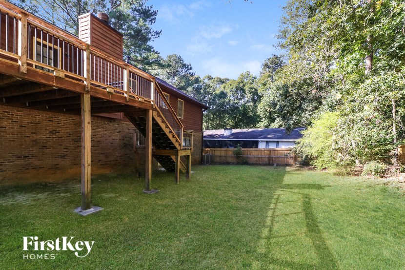 a large backyard with a deck and a log cabin