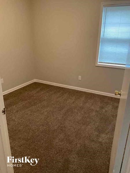 an empty room with a carpeted floor and a window