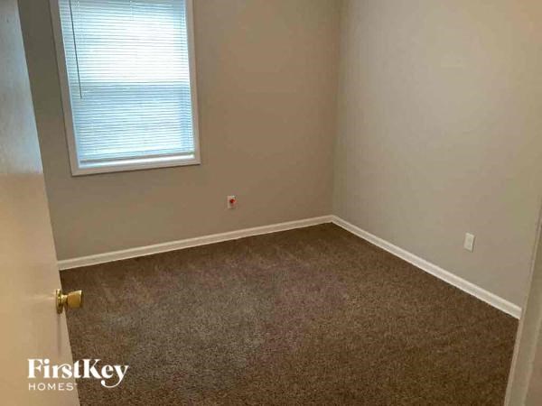 an empty room with a window and a carpet