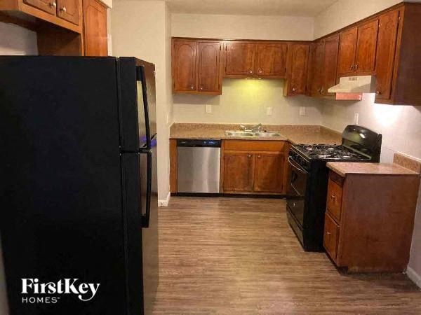 a kitchen with wooden cabinets and a black refrigerator