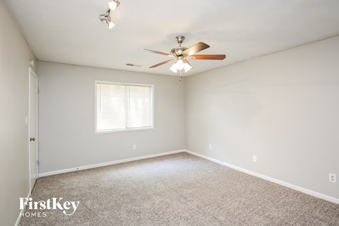 a bedroom with white carpet and a ceiling fan