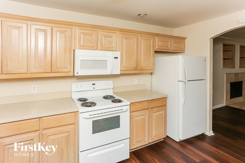 A kitchen with wooden cabinets and white appliances.