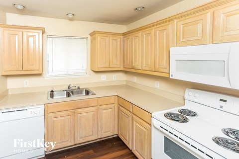 A kitchen with wooden cabinets and white appliances.