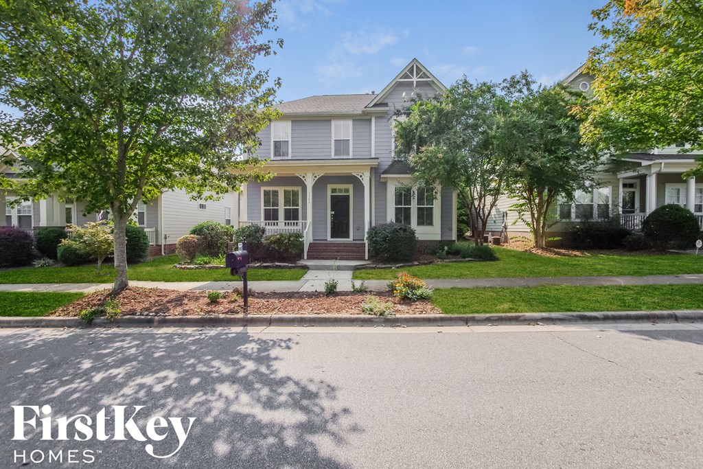 a house with a driveway and trees in front of it
