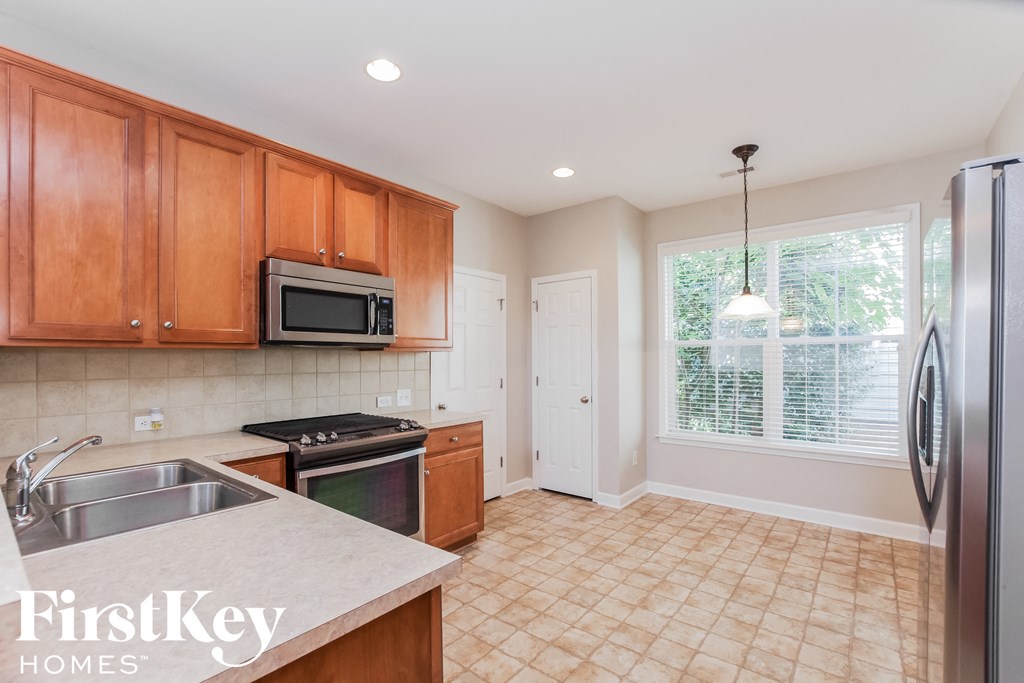 an empty kitchen with wooden cabinets and stainless steel appliances