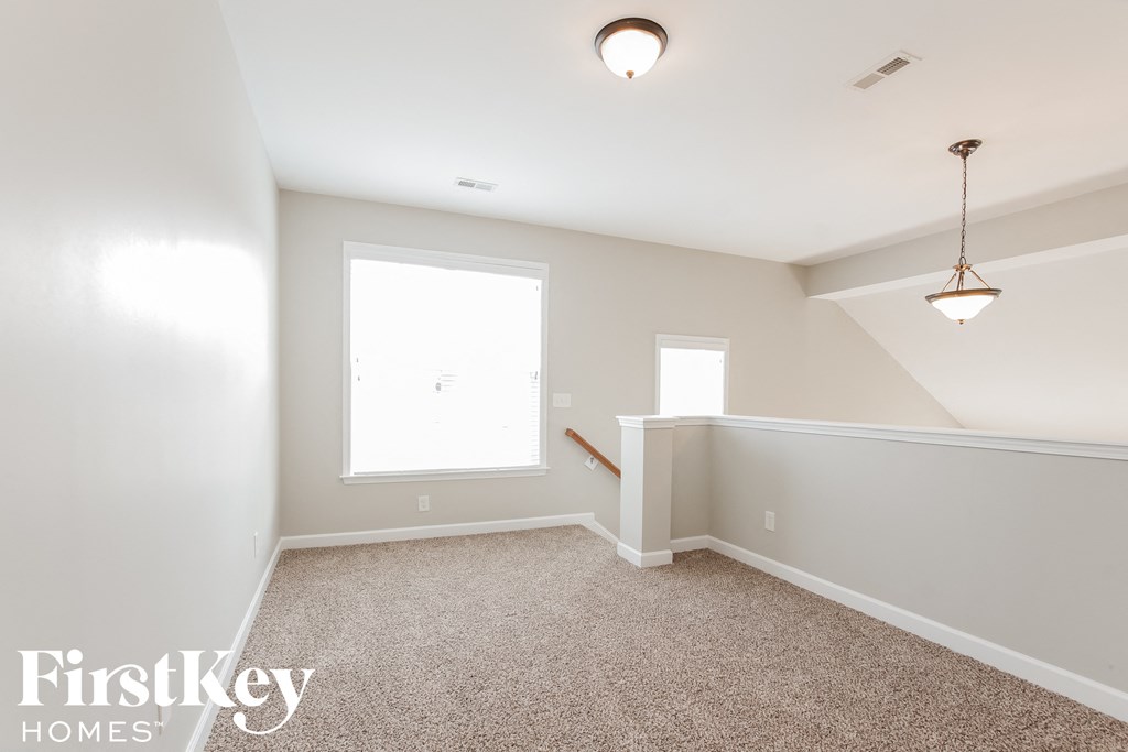 a small white room with a carpeted floor and a window
