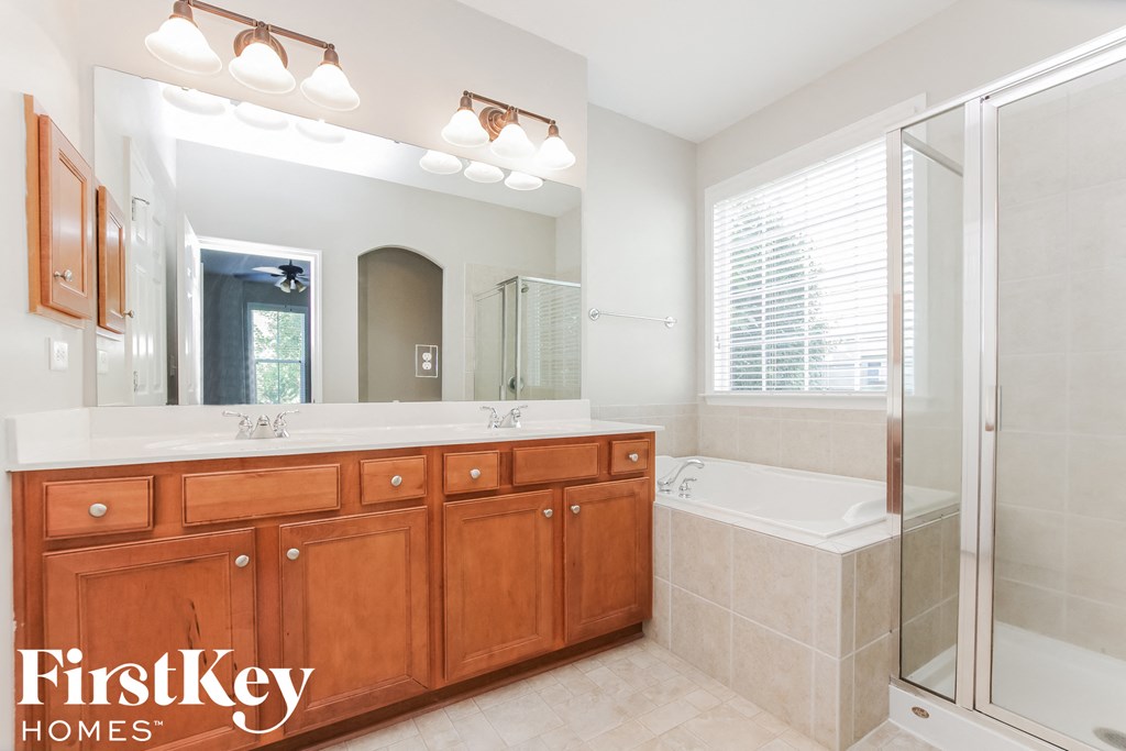 a bathroom with a large vanity and a tub and a shower