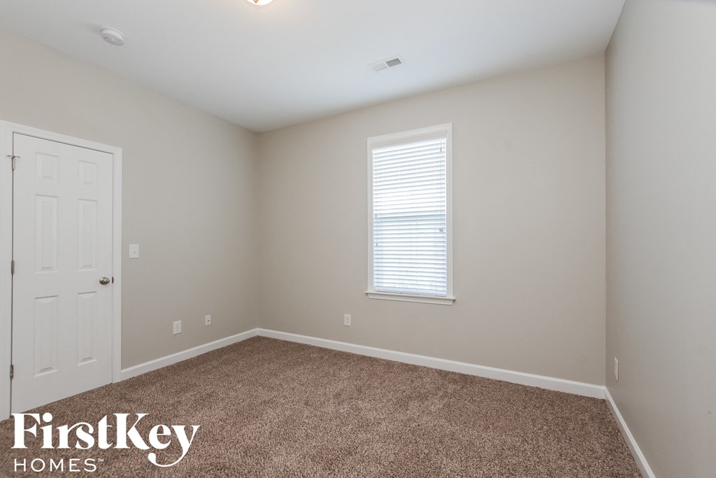 a bedroom with a carpeted floor and a white door