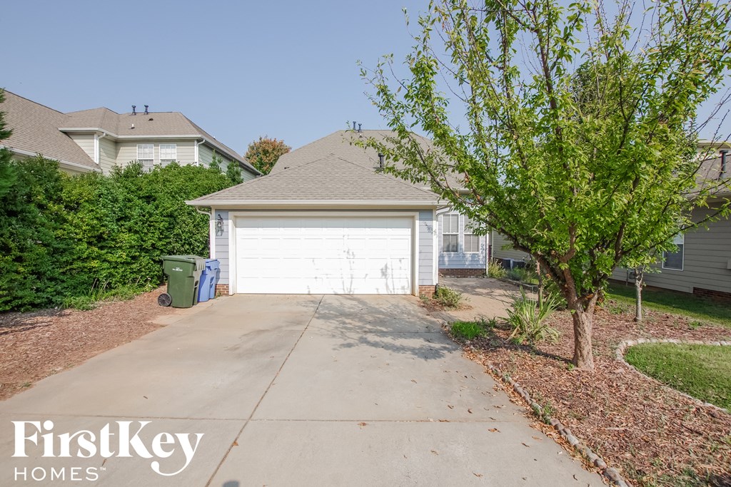 a white garage door at the end of a driveway