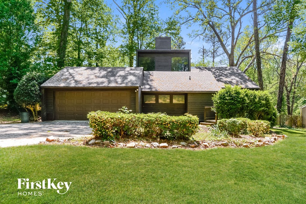 the front of a house with a garage and a lawn