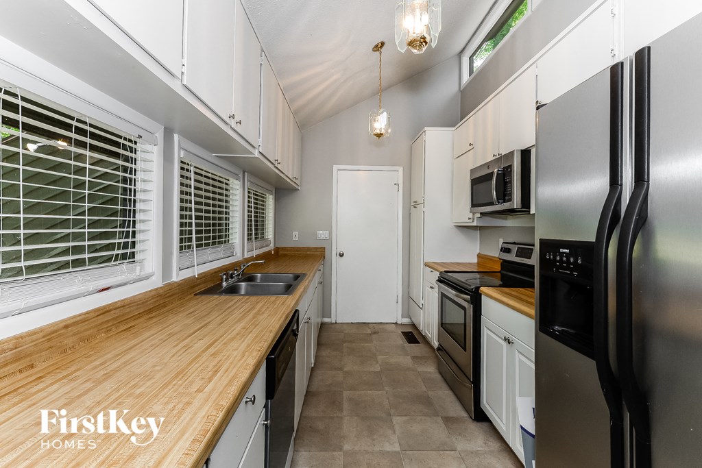 a kitchen with stainless steel appliances and a wooden counter top